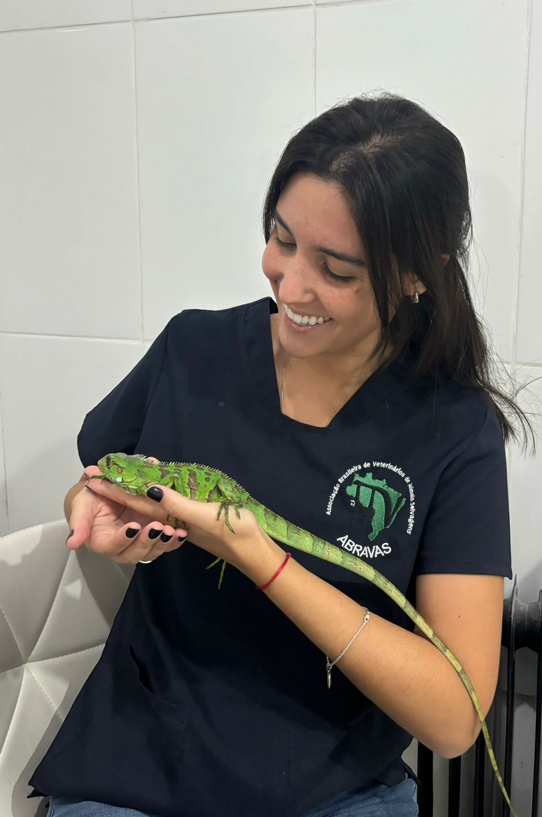 Médica veterinária Fernanda Vilardi com uma arara-vermelha no colo